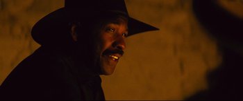Movie still from “The Magnificent Seven” (2016), directed by Antoine Fuqua – A person wearing a hat; Close Up shot, Over the shoulder angle