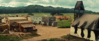 Movie still from “The Magnificent Seven” (2016), directed by Antoine Fuqua – An old western town with horses and a horse - drawn carriage; Extreme Wide shot, High angle