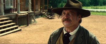 Movie still from “The Magnificent Seven” (2016), directed by Antoine Fuqua – An older man wearing a hat and a vest; Close Up shot, Over the shoulder angle