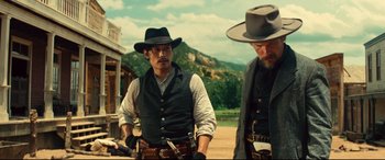 Movie still from “The Magnificent Seven” (2016), directed by Antoine Fuqua – A man in a cowboy hat standing next to another man in a cowboy hat; Medium shot, Low angle