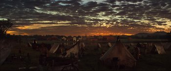 Movie still from “The Magnificent Seven” (2016), directed by Antoine Fuqua – An image of tents set up in a field at sunset; Extreme Wide shot, Low angle