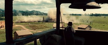 Movie still from “The Magnificent Seven” (2016), directed by Antoine Fuqua – An old man is standing on the porch of an old farm house; Extreme Wide shot, Over the shoulder angle