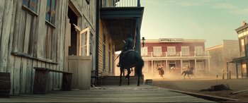 Movie still from “The Magnificent Seven” (2016), directed by Antoine Fuqua – A man riding a horse down the steps of a building; Wide shot, Low angle