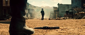 Movie still from “The Magnificent Seven” (2016), directed by Antoine Fuqua – A man standing in the middle of a dirt field; Wide shot, Low angle