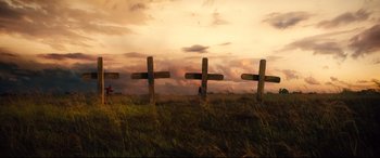 Movie still from “The Magnificent Seven” (2016), directed by Antoine Fuqua – A row of wooden crosses sitting in a grassy field; Extreme Wide shot, Low angle