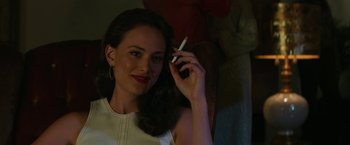 Movie still from “The Offer” (2022), directed by Dexter Fletcher – A woman holding a cell phone up to her ear; Close Up shot, Over the shoulder angle