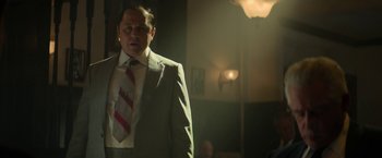 Movie still from “The Offer” (2022), directed by Dexter Fletcher – A man in a suit and tie standing in a room; Medium shot, Low angle