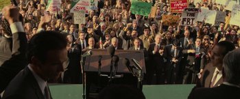 Movie still from “The Offer” (2022), directed by Dexter Fletcher – A crowd of people standing in front of microphones and microphones; Wide shot, High angle