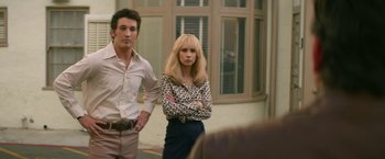 Movie still from “The Offer” (2022), directed by Dexter Fletcher – A man and a woman standing next to each other in front of a building; Medium shot, Over the shoulder angle