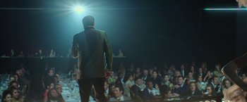 Movie still from “The Offer” (2022), directed by Dexter Fletcher – A man standing in front of a crowd of people; Wide shot, Over the shoulder angle