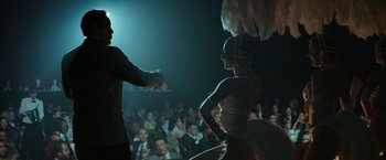 Movie still from “The Offer” (2022), directed by Dexter Fletcher – A man and a woman are performing in front of an audience; Medium shot, Over the shoulder angle