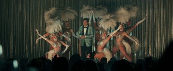 Movie still from “The Offer” (2022), directed by Dexter Fletcher – A man in a suit standing in front of a group of dancers; Wide shot, High angle