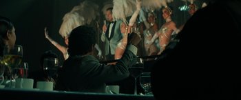 Movie still from “The Offer” (2022), directed by Dexter Fletcher – A man sitting at a table in front of a group of people; Medium shot, Over the shoulder angle