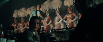 Movie still from “The Offer” (2022), directed by Dexter Fletcher – A man sitting in front of a group of dancers; Medium shot, Over the shoulder angle