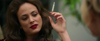 Movie still from “The Offer” (2022), directed by Dexter Fletcher – A woman is holding a cigarette in her hand; Close Up shot, Over the shoulder angle