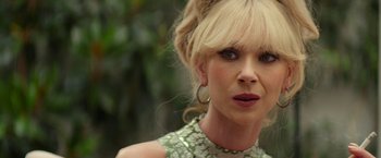 Movie still from “The Offer” (2022), directed by Dexter Fletcher – A person with blond hair wearing a green dress; Close Up shot, Over the shoulder angle