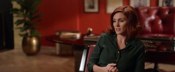 Movie still from “The Offer” (2022), directed by Dexter Fletcher – A woman sitting in a chair in a room; Medium shot, Over the shoulder angle