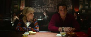 Movie still from “The Offer” (2022), directed by Dexter Fletcher – A man and a woman sitting at a table in a restaurant; Medium shot, Over the shoulder angle