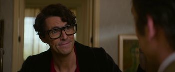 Movie still from “The Offer” (2022), directed by Dexter Fletcher – A person wearing glasses and a jacket; Close Up shot, Over the shoulder angle