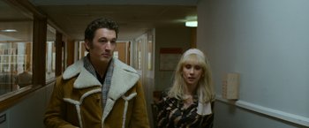 Movie still from “The Offer” (2022), directed by Dexter Fletcher – A man and a woman standing next to each other in a hallway; Medium shot, Low angle