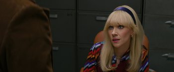 Movie still from “The Offer” (2022), directed by Dexter Fletcher – A woman sitting in a chair wearing a colorful shirt; Close Up shot, Over the shoulder angle