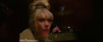 Movie still from “The Offer” (2022), directed by Dexter Fletcher – A woman is sitting at a table and talking on the phone; Close Up shot, Low angle