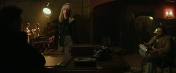 Movie still from “The Offer” (2022), directed by Dexter Fletcher – A woman sitting at a table with a camera; Medium shot, Over the shoulder angle