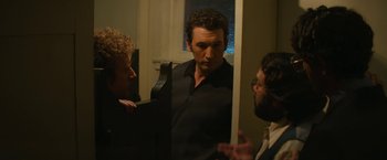 Movie still from “The Offer” (2022), directed by Dexter Fletcher – A group of men standing around a mirror; Medium shot, Over the shoulder angle