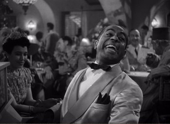 Movie still from “Casablanca” (1942), directed by Michael Curtiz – A black and white photo of a man in a tuxedo; Medium shot, Low angle