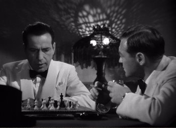 Movie still from “Casablanca” (1942), directed by Michael Curtiz – Two men sitting at a table with a chess board; Medium shot, Over the shoulder angle