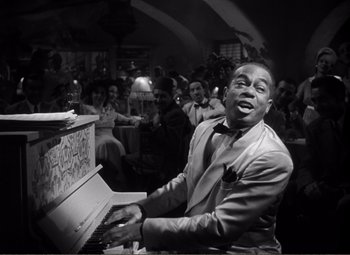 Movie still from “Casablanca” (1942), directed by Michael Curtiz – A black and white photo of a man playing the piano; Medium shot, High angle