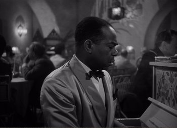 Movie still from “Casablanca” (1942), directed by Michael Curtiz – A black and white photo of a man in a suit; Medium shot, High angle