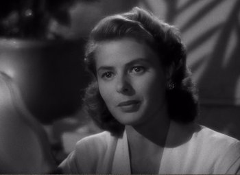 Movie still from “Casablanca” (1942), directed by Michael Curtiz – A black - and - white photo of a woman in a white shirt; Close Up shot, Over the shoulder angle