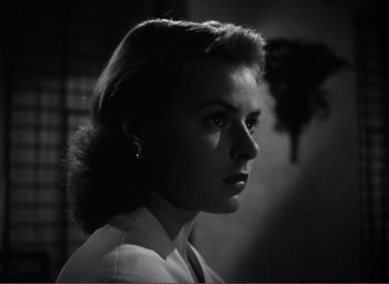 Movie still from “Casablanca” (1942), directed by Michael Curtiz – A black - and - white photo of a woman in a white shirt; Close Up shot, Low angle