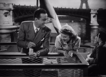 Movie still from “Casablanca” (1942), directed by Michael Curtiz – A man and a woman sitting at an outdoor table; Medium shot, High angle