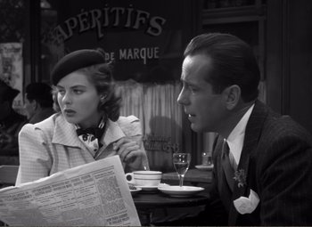 Movie still from “Casablanca” (1942), directed by Michael Curtiz – A man and a woman sitting in front of a newspaper; Close Up shot, Over the shoulder angle