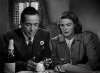 Movie still from “Casablanca” (1942), directed by Michael Curtiz – A man and a woman sitting at a dinner table; Close Up shot, Over the shoulder angle