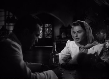 Movie still from “Casablanca” (1942), directed by Michael Curtiz – A man and a woman sitting at a table with a bottle of beer; Close Up shot, Over the shoulder angle