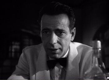 Movie still from “Casablanca” (1942), directed by Michael Curtiz – Black and white photograph of a man wearing a suit and bow tie; Close Up shot, Low angle