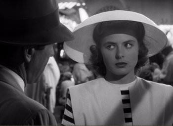 Movie still from “Casablanca” (1942), directed by Michael Curtiz – A woman wearing a hat standing next to a man wearing a hat; Close Up shot, Over the shoulder angle