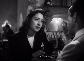Movie still from “Casablanca” (1942), directed by Michael Curtiz – A woman sitting at a table with a glass of wine in front of a man; Close Up shot, Over the shoulder angle