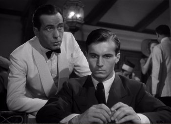 Movie still from “Casablanca” (1942), directed by Michael Curtiz – A man in a suit and tie next to another man in a suit and tie; Medium shot, Low angle