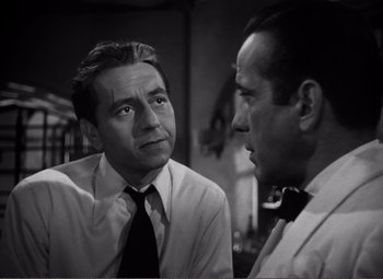 Movie still from “Casablanca” (1942), directed by Michael Curtiz – Two men are talking to each other in a black and white photo; Close Up shot, Over the shoulder angle
