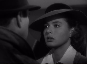 A man and a woman in a hat looking at each other
