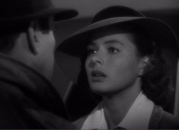 Movie still from “Casablanca” (1942), directed by Michael Curtiz – A man and a woman in a hat looking at each other; Close Up shot, Over the shoulder angle