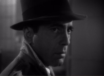 Movie still from “Casablanca” (1942), directed by Michael Curtiz – Black and white photograph of a man wearing a hat; Close Up shot, Low angle