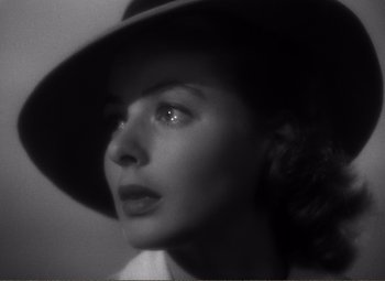 Movie still from “Casablanca” (1942), directed by Michael Curtiz – A black and white photo of a woman wearing a hat; Close Up shot, High angle