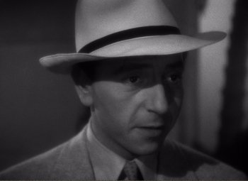 Movie still from “Casablanca” (1942), directed by Michael Curtiz – A black and white photo of a man wearing a hat; Close Up shot, High angle