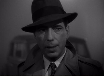 Movie still from “Casablanca” (1942), directed by Michael Curtiz – A black and white photo of a man wearing a hat; Close Up shot, Low angle