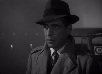 Movie still from “Casablanca” (1942), directed by Michael Curtiz – A black and white photo of a man wearing a hat; Close Up shot, Over the shoulder angle